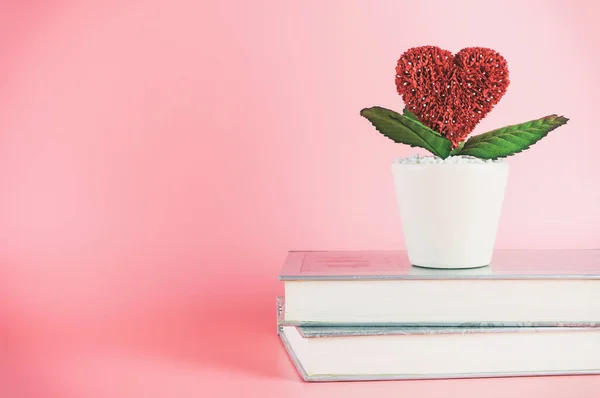 Love heart flower on books with pink copy space
