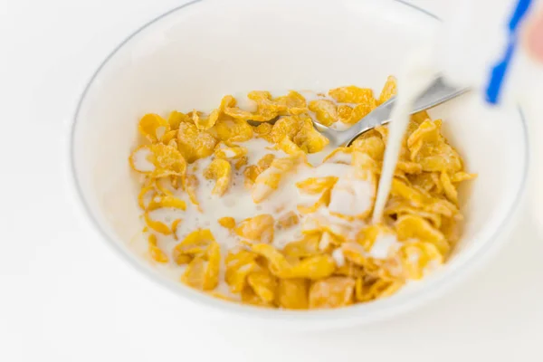 Verter leche en un tazón de cereal endulzado —  Fotos de Stock