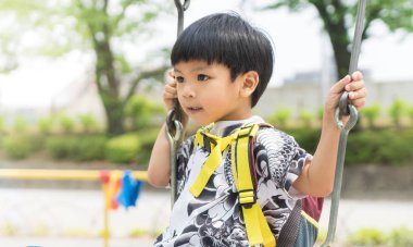 Asyalı Çocuk Bahçesi salıncakta sallanan