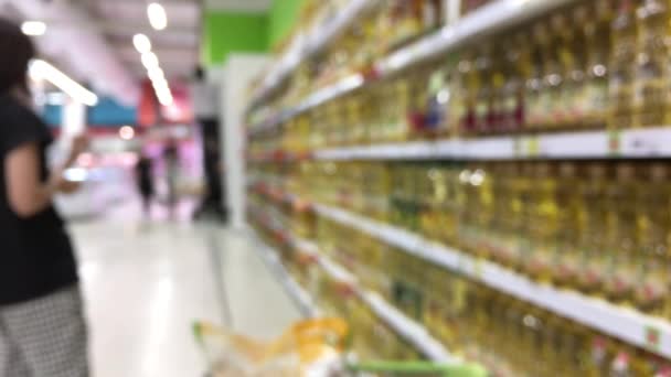 Supermercato con sehlf pieno di olio da cucina per la vostra scelta. Una moglie di casa sta scegliendo l'olio da cucina . — Video Stock