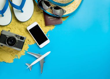 Plaj yaz tatili seyahat aksesuarları ve moda kum üzerinde ve mavi arka plan.