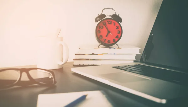 Reloj despertador rojo en la mesa de la oficina con objetos — Foto de Stock