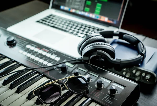 Εξοπλισμός στούντιο μουσικής υπολογιστή με γυαλιά ηλίου σε συνθεσάιζερ — Φωτογραφία Αρχείου