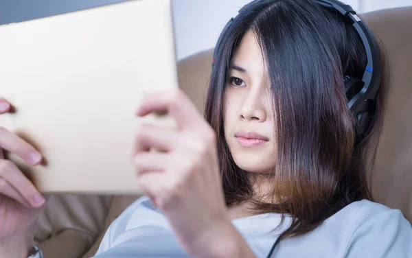 Aziatisch meisje kijkt reeks video op Tablet PC — Stockfoto