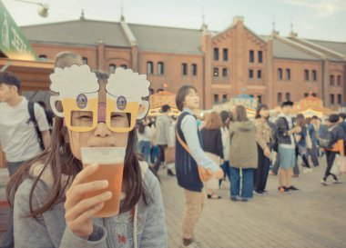 İnsanlar Bira Festivali Yokohama kırmızı tuğla ambar bira içiyorlar.