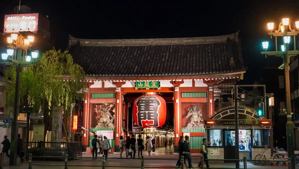 La gente sta camminando attraverso il cancello rosso del santuario di Sensoji . — Foto Stock