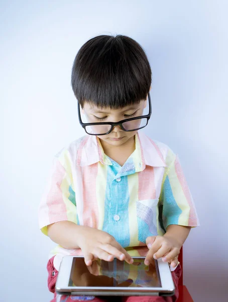 Nerd niño asiático está jugando juego de educación en la tableta sobre fondo blanco — Foto de Stock