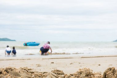Asya aile bir kum plajı üzerinde oynuyor 