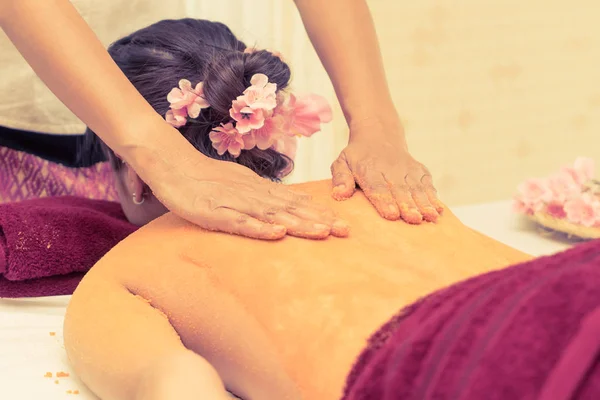 Thai Spa Therapist sta strofinando il sale arancione sulla schiena di una donna — Foto Stock