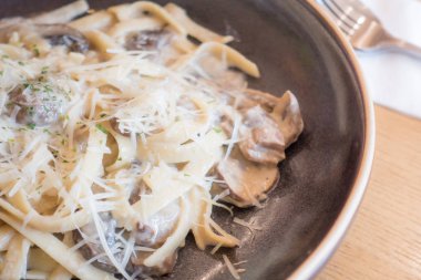 Kahverengi bir tabak mantarlı kremalı makarna