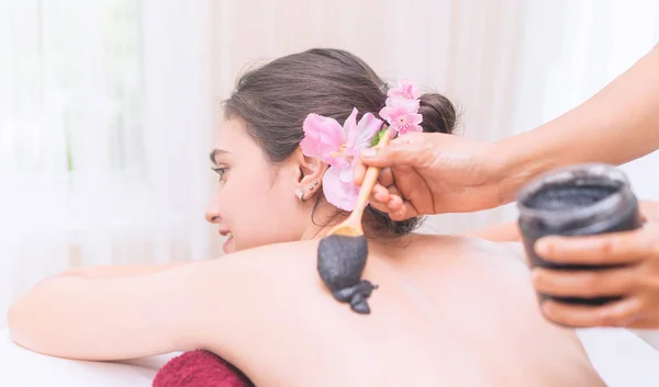 Las mujeres están recibiendo Spa Charcoal Scrub en su espalda —  Fotos de Stock