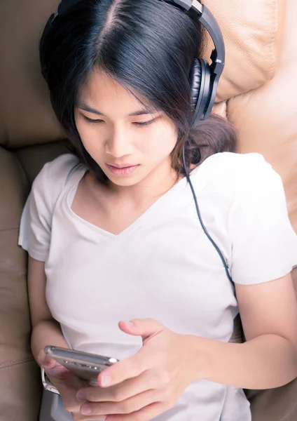 Koltukta yalan kadındır cep telefonu kulaklık kullanarak müzik dinle
