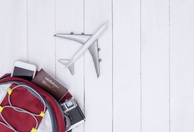 Seyahat etmek sırt çantası Beyaz ahşap kopyalama alanı üzerinde uçan uçak