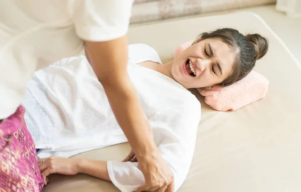 Les femmes souffrent tandis que la thérapeute pousse son bras pour la réflexologie dans le cours de massage thaï — Photo