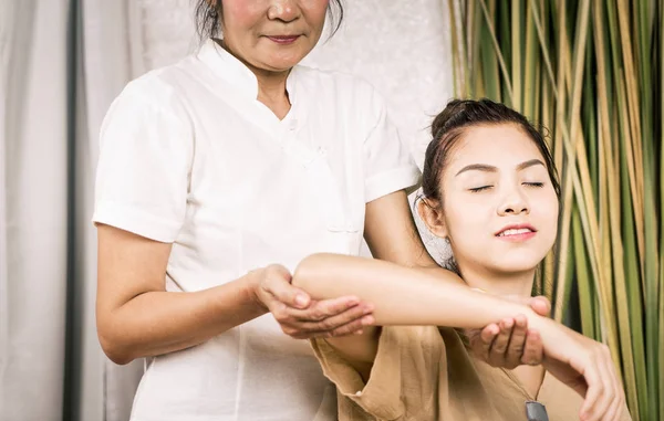 Women is getting Thai massage stretching position on her arm. — Stock Photo, Image