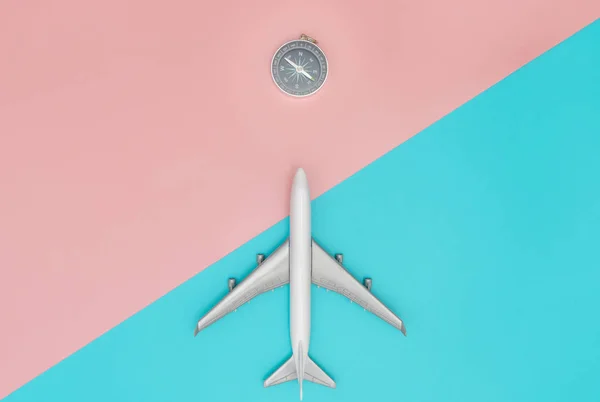 Pusula yönü ile pastel arka plan üzerinde uçan oyuncak uçak — Stok fotoğraf