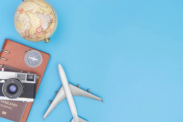 Viagens aéreas com globo e objetos no espaço de cópia azul — Fotografia de Stock