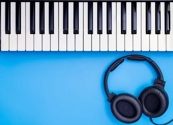 Music Keyboard and headphone for Music Lesson, Music Studio concept with blue copy space