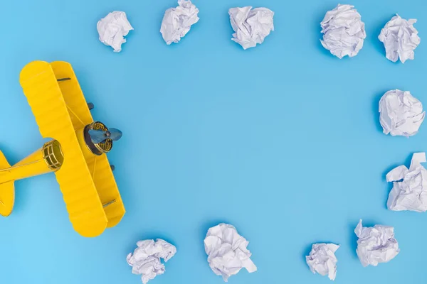 Plano de brinquedo amarelo no fundo azul com nuvem de papel — Fotografia de Stock