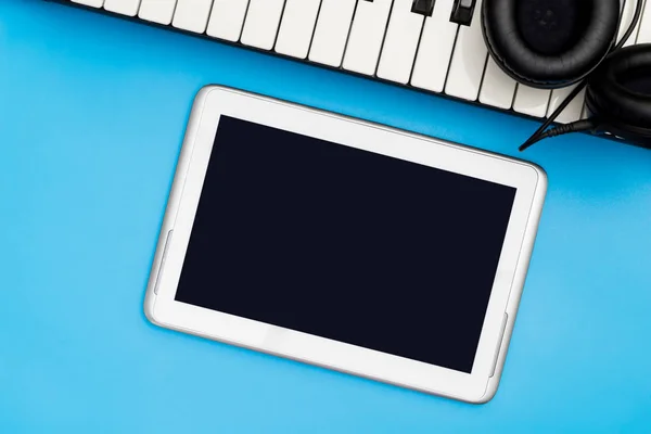 Boş müzik tablet ekranıyla müzik klavye ve mavi kulaklık — Stok fotoğraf