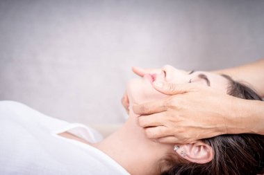 Asyalı kadınlar yüz masaj yan görünümü ile çimento duvar kopya alanı oluyor