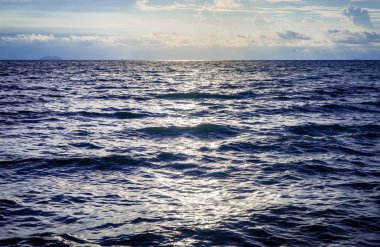 Koyu mavi okyanus dalgası üzerinde dramatik gökyüzü