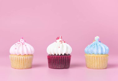 Kopya alanı ile pembe arka plan üzerinde üç renkli Cupcake