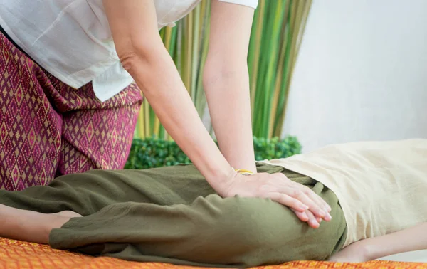Thailändischer Wellness-Therapeut massiert Frau das Bein — Stockfoto