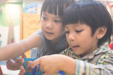 İki küçük çocuğu sınıfta eğitici oyuncak ile oynuyorlar