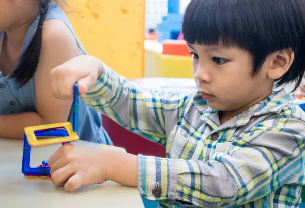 Asyalı çocuk sınıf eğitim oyuncak ile oynuyor