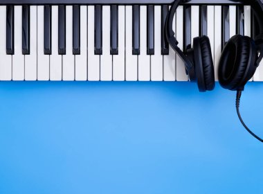 Music headphone on Music keyboard on blue copy space for Music concept clipart