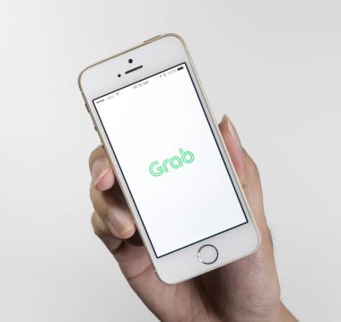 Bangkok, Tayland - 22 Eylül 2017: Bir adam taksi kapmak uygulaması ile mobil tutuyor.