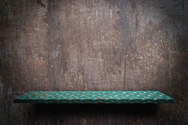 Green metal shelf display counter on grungy wall