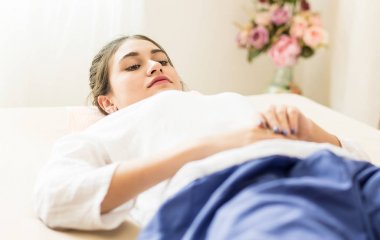 Güzel kadın masaj için spa yatakta yatıyor