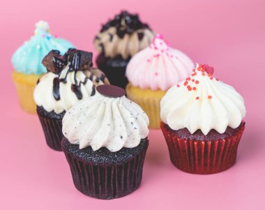 Pembe bir arka plan üzerinde altı mini süslü Top kek