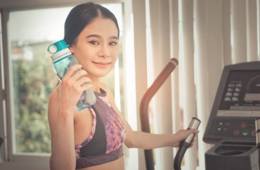 Tatlı su onun elinde tutan koşu bandı üzerinde çalışan kadın