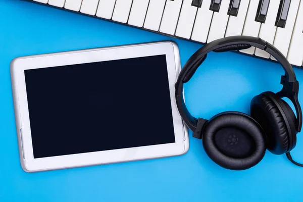 蓝色背景上带有耳机和键盘的空白 Tablet — 图库照片