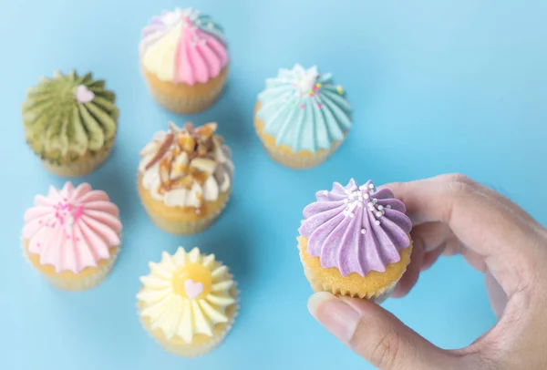 Mão Segurando Cupcake Roxo Com Cupcake Colorido Fundo — Fotografia de Stock