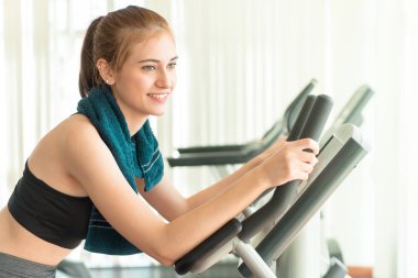 Güzel kadın egzersiz bisikleti üzerinde çalışıyor