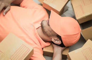 Turuncu ambalaj kutuları üzerinde uyku kurye