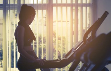 Fitness salonunda koşu bandı makinesinde çalışan kadın