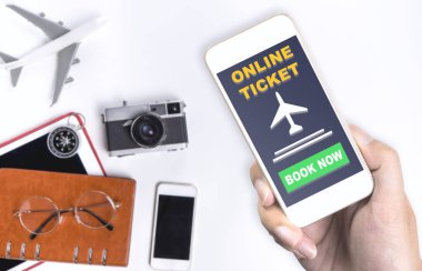 Online seyahat bilet uygulaması üstünde hareket eden telefon tutarak