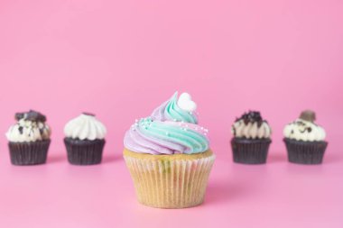Gökkuşağı süslü cupcake pembe üzerinde çikolatalı kek ile