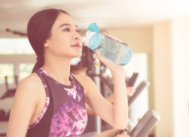 Spor kadın fitness egzersiz yaparken tatlı su içiyor