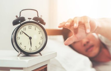 Elini çalar saat erken sabah uyanma için uzanarak