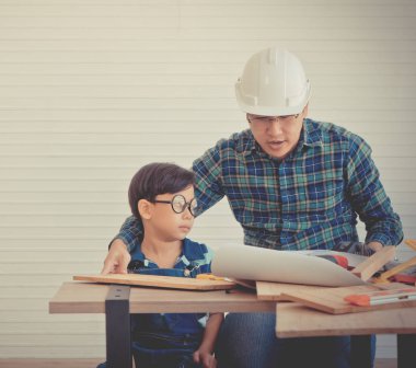 Küçük Çocuk ahşap üzerinde çalışmayı öğreniyor ve onun sayesinde inşaatçı oluyor.