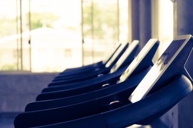 Sağlıklı bir spor salonunda dört koşu bandı yan görünümü. 