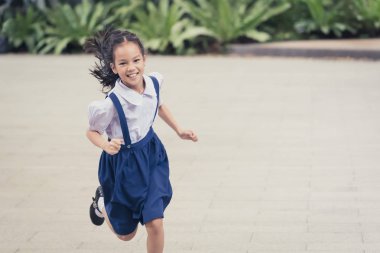 Asyalı Bayan Öğrenci Bahçede sırıtarak koşuyor