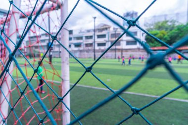 Çocuk futbol antrenmanını arka planda yapıyor.