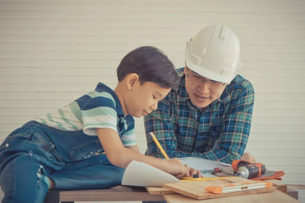 Маленький хлопчик вчиться працювати на дереві і буде будівельником зі свого — стокове фото